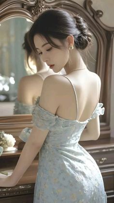 Woman in a light blue dress with bare shoulders and an updo hairstyle