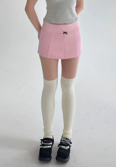 Person wearing a pink mini skirt, knee-high socks, and mary jane shoes