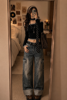 Woman taking a mirror selfie in a crop top and cargo jeans