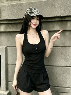 Woman in a black halter top and camouflage cap pointing to the side