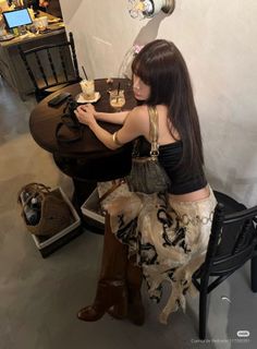 Woman with long hair wearing a crop top and midi skirt in a cafe