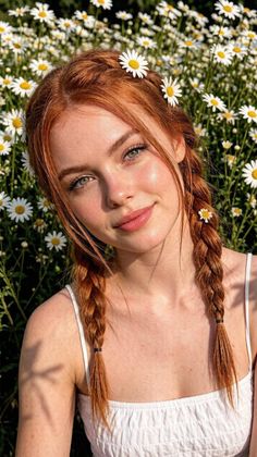 Woman with red braided hair and daisies in a field of flowers