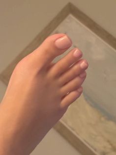 A close up photograph of a foot with pink nail polish