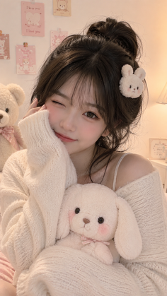 Woman with a messy bun and bunny hair clip holding a stuffed animal
