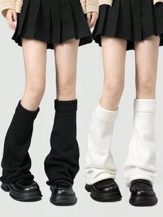 Two people wearing pleated skirts, leg warmers, and chunky black shoes