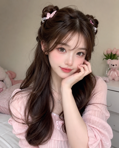 Woman with long brown hair and pink butterfly clips wearing a pink top