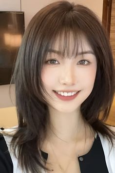 Woman with medium brown hair and bangs smiling at the camera