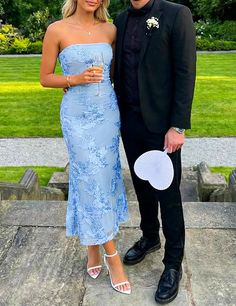 Couple dressed in formal wear standing outdoors on stone steps