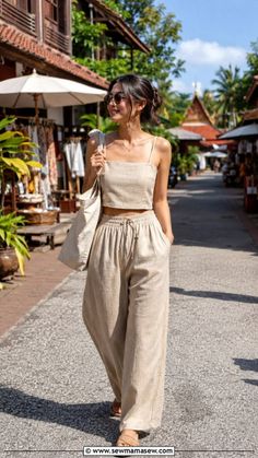 Woman in a crop top and wide leg pants walking on a street