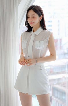 Woman in a white sleeveless shirt and short skirt indoors