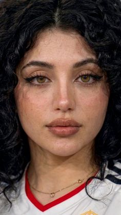 Close up portrait of a woman with curly black hair and brown eyes
