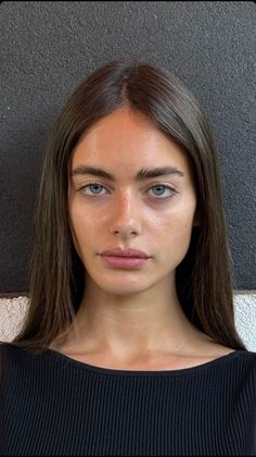Woman with long dark hair and blue eyes in a black top