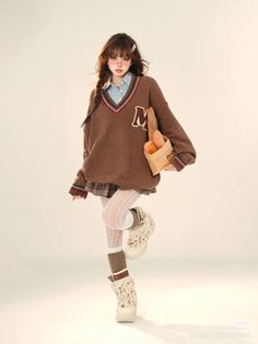 Woman in an oversized sweater, plaid skirt, and furry boots holding baguettes