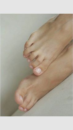 Close up of feet with a light pink pedicure and small rhinestones