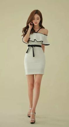 Woman in a white off-shoulder dress with a black belt and high heels