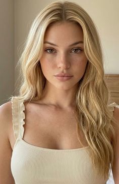 Woman with blonde hair and freckles wearing a ribbed top with ruffle straps