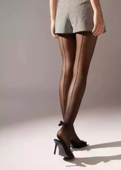 Person wearing black sheer tights with bows and gingham shorts