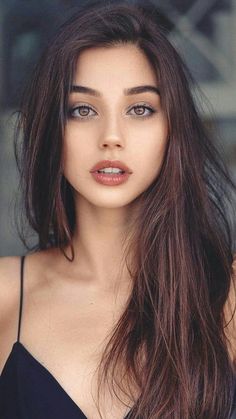 Woman with long brown hair and brown eyes wearing a black top