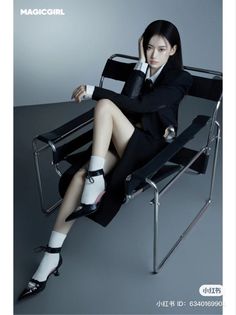Woman in a black suit and white socks sitting on a chair indoors