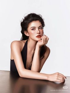 Woman in a black halter top with red lipstick and freckles posing in a studio