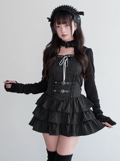 Woman in a black gothic dress with a choker and headband against a white background