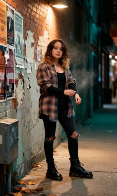 Woman in a plaid shirt and ripped jeans standing on a street at night