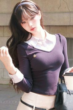 Woman with long hair and a headband wearing a v-neck shirt with a white collar