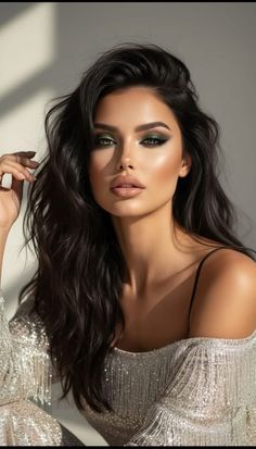 Woman with dark hair and dramatic makeup wearing a sparkly off-shoulder dress