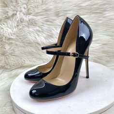 Pair of black patent leather mary jane high heels with ankle straps