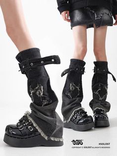 Two people wearing black platform boots and distressed denim clothing