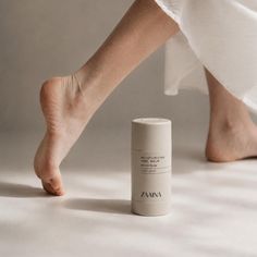 Bare feet and a moisturizing heel balm on a light background