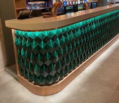 Modern bar counter with green geometric tiles and LED lighting