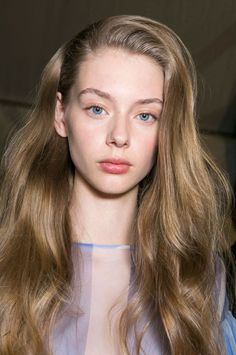 Woman with long wavy hair and blue eyes in a soft light