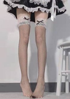 Person wearing fishnet stockings with lace trim and a maid dress