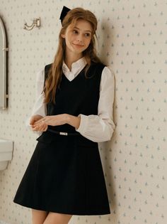 Woman with long hair and a black bow in a black dress and white shirt