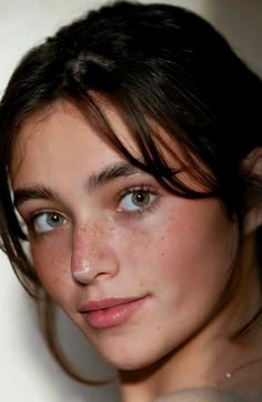 Close up portrait of a young woman with green eyes and freckles