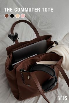 Brown tote bag filled with everyday items on a white bed