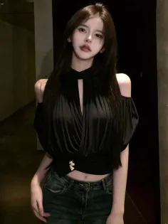 Woman with long dark hair wearing a black top and jeans