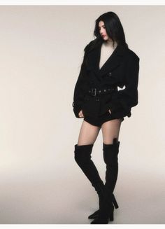 Woman with long black hair wearing a black jacket and thigh-high boots