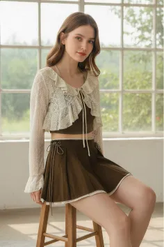 Woman in a lace cardigan and pleated skirt sitting indoors