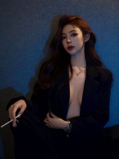 Woman with long hair wearing an open black blazer with deep cleavage