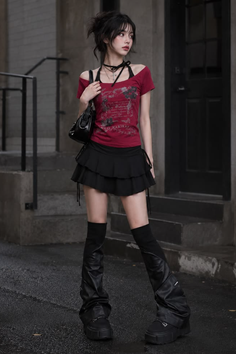 Woman with dark hair wearing a red top and black mini skirt outdoors