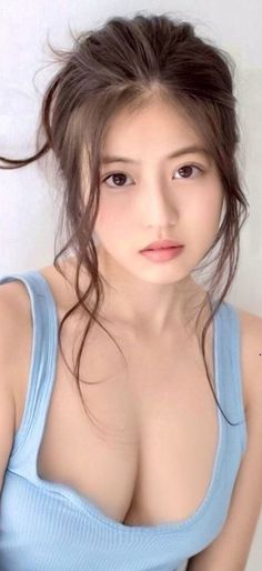 Woman with a messy bun and light blue top showing cleavage
