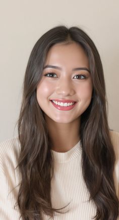 Smiling woman with long brown hair wearing a white sweater