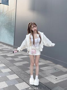 Woman in a white outfit with a ponytail and fluffy slippers outdoors