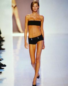 Woman in a black strapless top and shorts walking on a runway