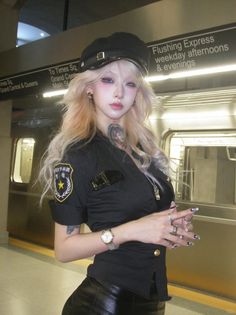 Woman in a police uniform and hat with long blonde hair at a subway station