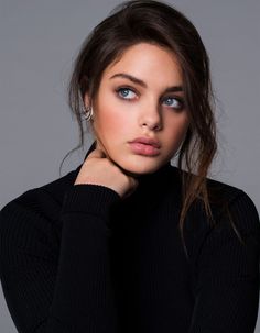 Woman with blue eyes and dark hair wearing a black turtleneck