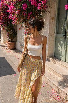Woman in a floral skirt and crop top walking outdoors on a sunny day