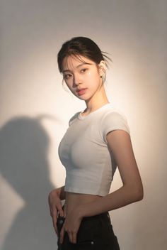 Woman in a white crop top and black pants with soft lighting